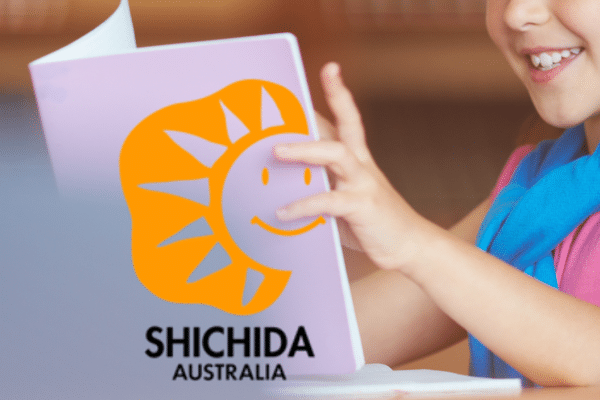 A picture for an article about a Shichida Baby that can read showing a young child holding up a book