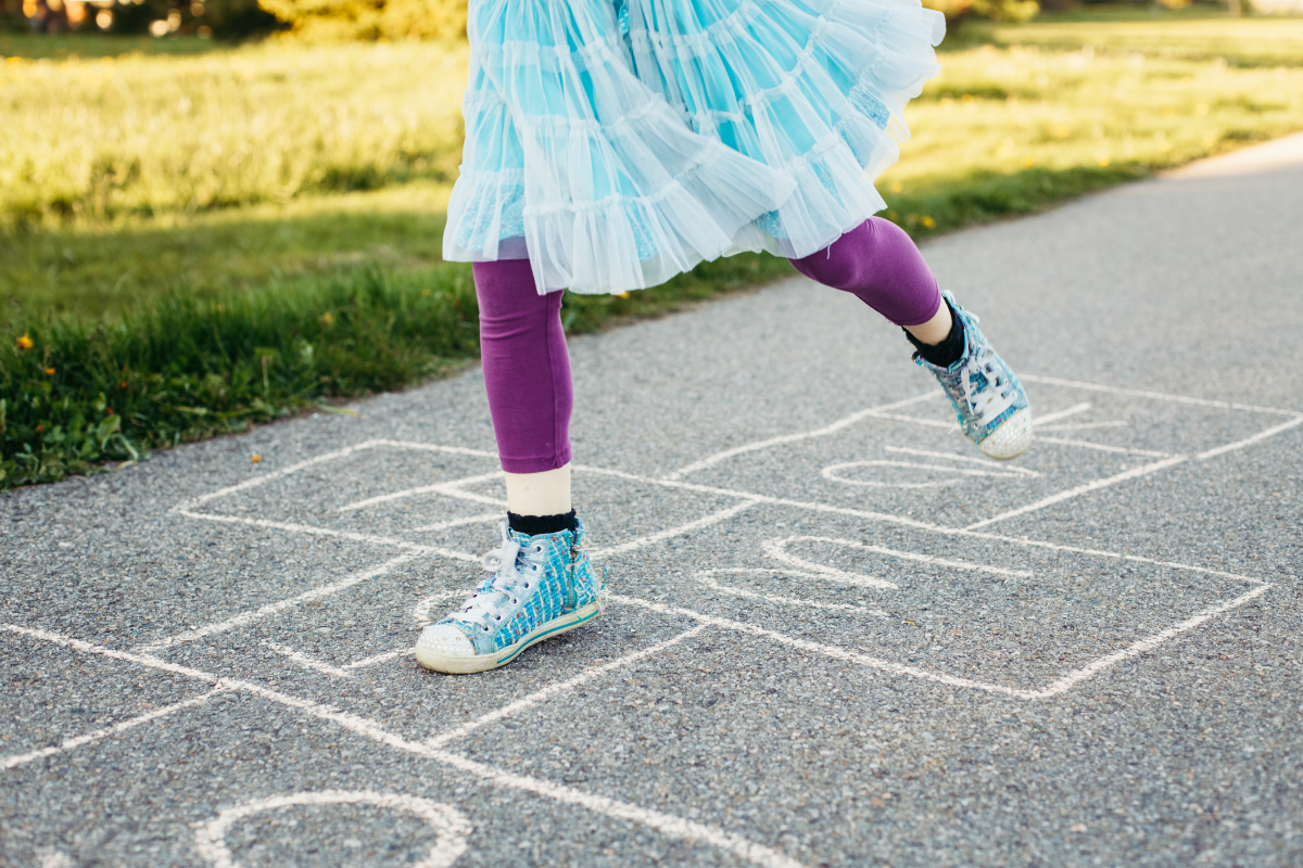 A young person playing hopscotch